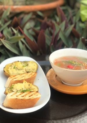 A picture of Thai vegetables soup with baked cheesy potatoes.