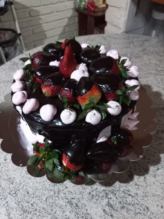 Una foto de Torta de chocolate con ganache de chocolate y frutillas 🍓