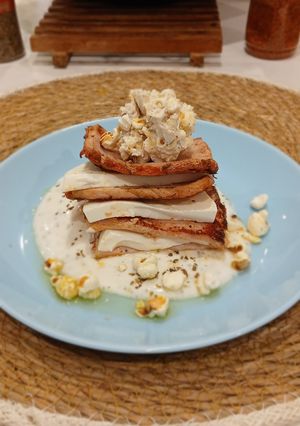 Una foto de Milhojas de Lomo Adobado y Queso Fresco con Tzatziki y Palomitas de Maiz