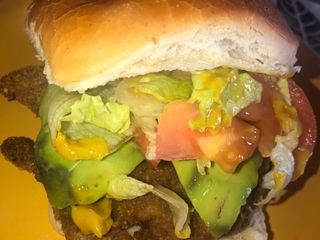 Súper sándwich de milanesa con palta, lechuga y tomate