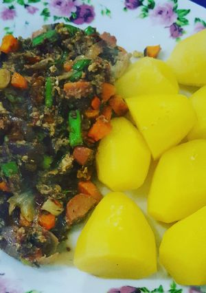 A picture of Boiled potatoes with veggie sausage egg sauce.