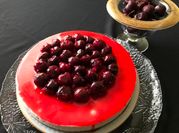 Una foto de tarta de queso y cerezas