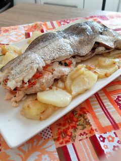 Una foto de Merluza rellena de gambones con cama de patata panaderas