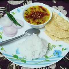 A picture of Tadke wali cury with rice.