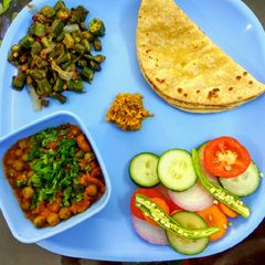 A picture of Lunch, chapati, salad, bhindi masala, soyabean matar ki sabzi.