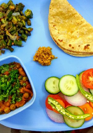 A picture of Lunch, chapati, salad, bhindi masala, soyabean matar ki sabzi.