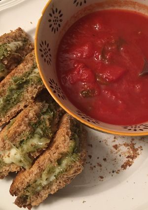 A picture of Low fat “grilled” cheese pesto sandwich and tomato soup.