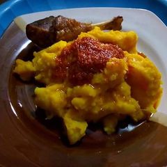 A picture of Potato porriage with tomato sauce and chicken.