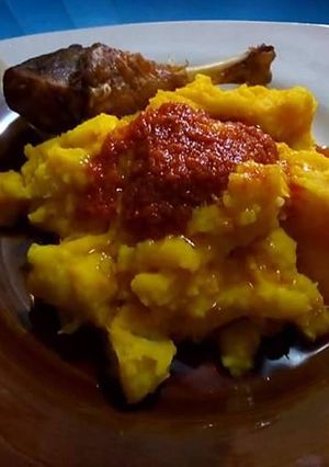 A picture of Potato porriage with tomato sauce and chicken.