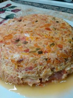 Una foto de Tortilla de tomates al horno rellena de jamón y queso