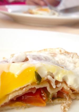 Una foto de Crêpes rellenas con jamón, tomate y cebolla salteado con albahaca y huevo frito