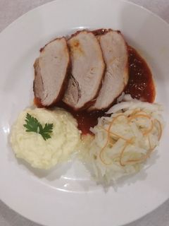 Una foto de Pierna de puerco en achiote acompañado de chucrut y puré de papa