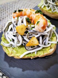 Una foto de Canapé de gulas con aguacate y gamba roja
