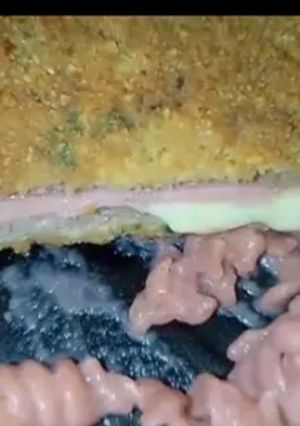Una foto de Milanesa de cuadril rellena de jamón y muzza,acompañado con unos tirabuzones con salsa de remolacha