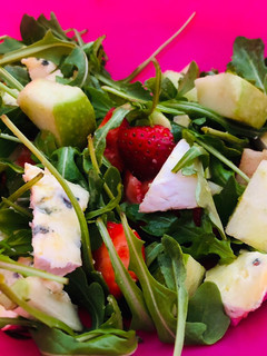 Una foto de Ensalada de rúcula, queso azul, manzana y fresa
