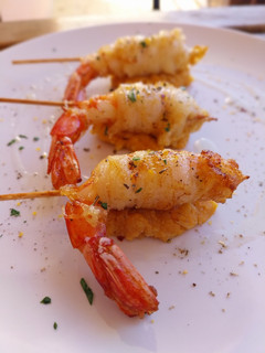 Una foto de Brocheta de gamba rebozada en fideo de arroz y quenelle de patatas revolconas