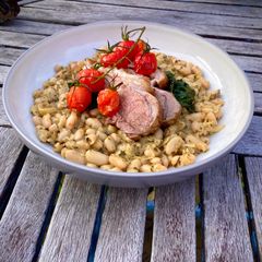 A picture of Zesty Pesto Beans with Dinosaur Kale and a rack of lamb.