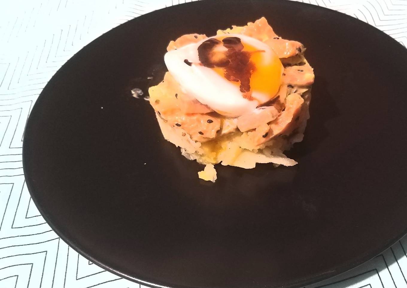 Redondito de salmón, aguacate y patata coronado con huevo ácido