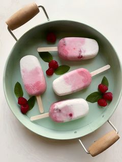 Una foto de Paletas de helado de coco, frambuesas y arándanos keto