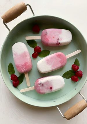 Una foto de Paletas de helado de coco, frambuesas y arándanos keto