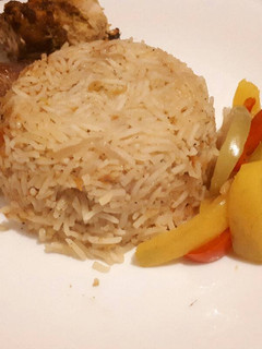 A picture of Jollof rice served with baked chicken.