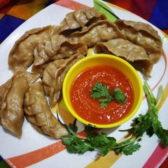 A picture of Steamed Wheat Momos Stuffed with Paneer and Veggies.