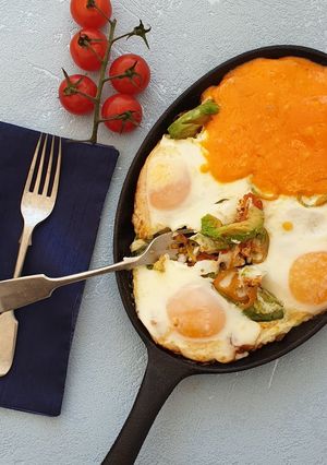 A picture of Baked eggs with tomatoes and avocado.