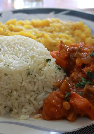 Una foto de Pollo entomatado con puré de plátano y arroz con cilantro y limón