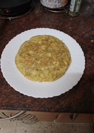 Una foto de Tortilla de papas con pata asada y cilantro
