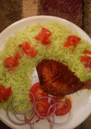 A picture of Colourd Rice with chicken stew and tomato's.