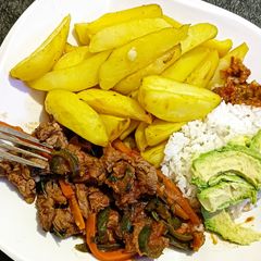 A picture of Baked potato wedges served with beef.