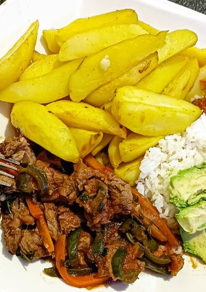 A picture of Baked potato wedges served with beef.