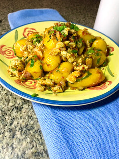 A picture of Pan fried potatoes with eggs and veggies.