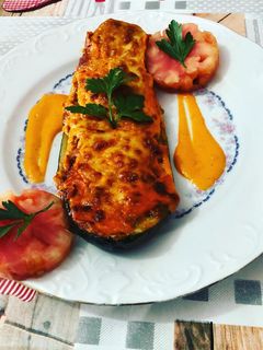 Una foto de Calabacines rellenos con gratinado de queso de oveja y salsa de pimientos del piquillo