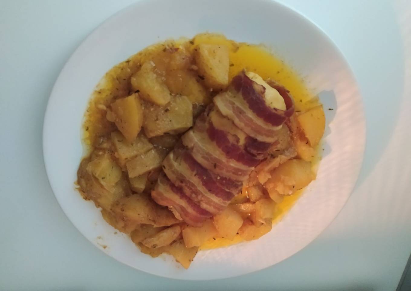 Pechuga de pollo rellena y envuelta en bacon con patatas al horno