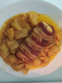 Una foto de Pechuga de pollo rellena y envuelta en bacon con patatas al horno