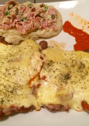 Una foto de Bondiola a la pizza acompañado de puré con salsa de queso, verdeo y jamón con reducción de pimiento ahumado