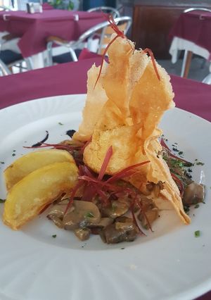 Una foto de Crujiente de huevo con salteado de setas y foie