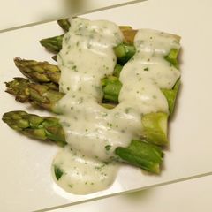 A picture of Steamed asparagus with fresh parsley sauce.