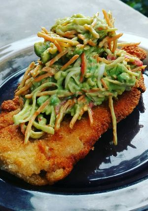 Una foto de Milanesa de pollo con topping de ensalada de Cangrejo