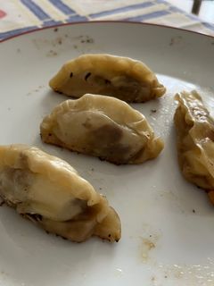 Una foto de Gyozas de cebolla caramelizada, carrilleras y queso de cabra