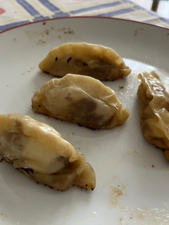 Una foto de Gyozas de cebolla caramelizada, carrilleras y queso de cabra