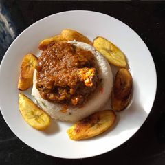 A picture of Rice and stew with plantain.