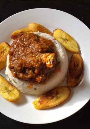 A picture of Rice and stew with plantain.