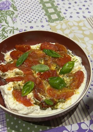 Una foto de Burrata con pesto y tomates confitados. Ideal entrada 🍅