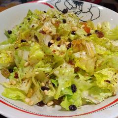 A picture of Green salad with molasses and dried fruits.