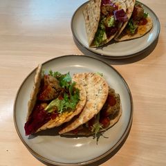 A picture of Flatbread with chickpeas, falafel & salad.