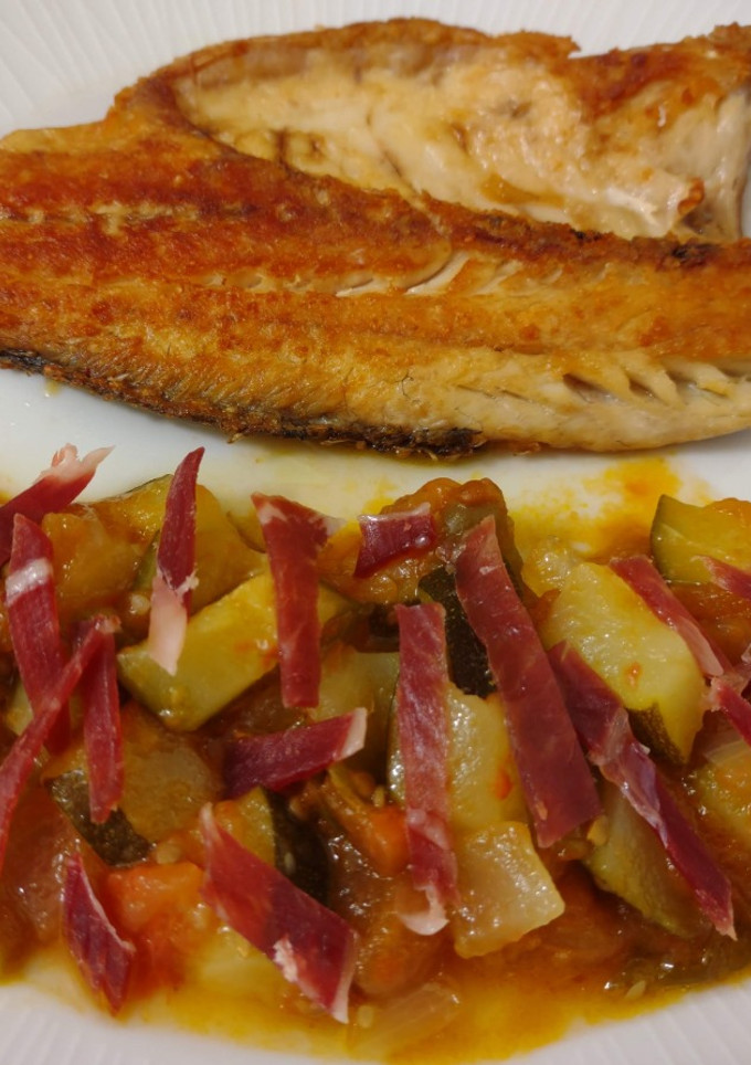 Una foto de Lubina a la plancha y pisto con jamón ibérico