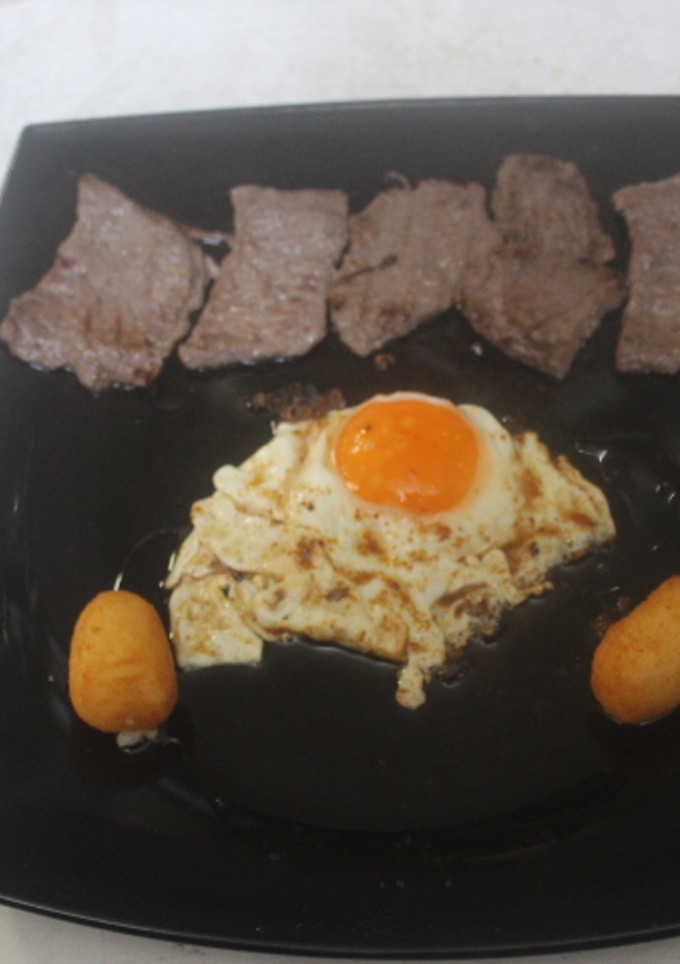 Una foto de Ternera troceada con huevo y croquetas