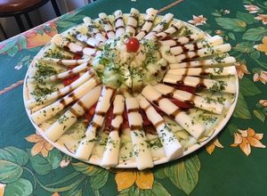 Une photo de Salade de concombres, tomates, coeurs de palmier au persil et crème de balsamique
